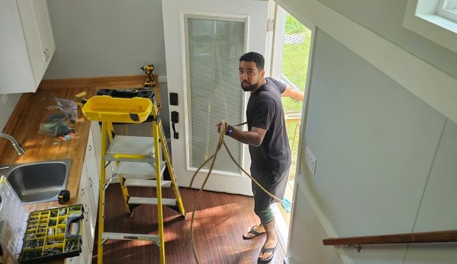 Mateus working inside a tiny house