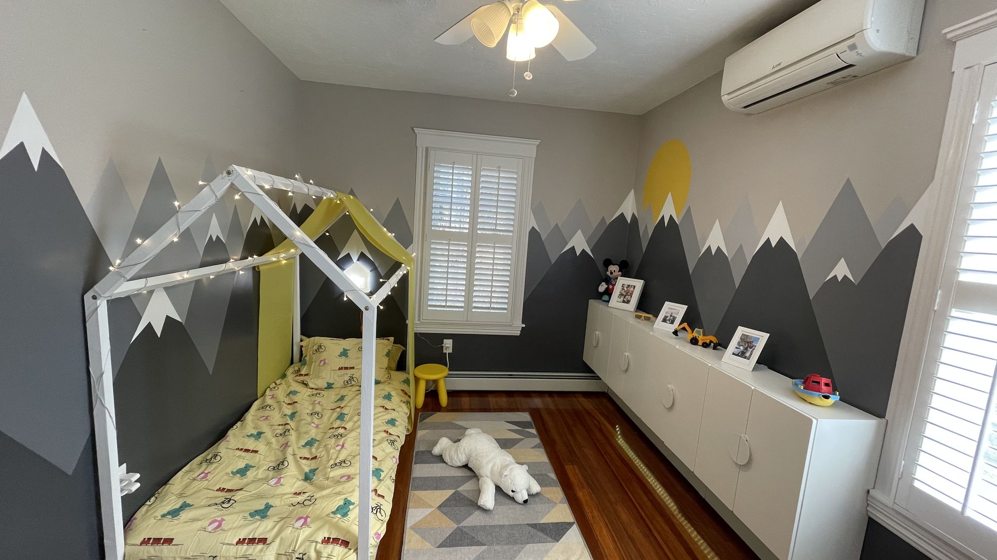 Kids bedroom with mountain mural and custom house bed