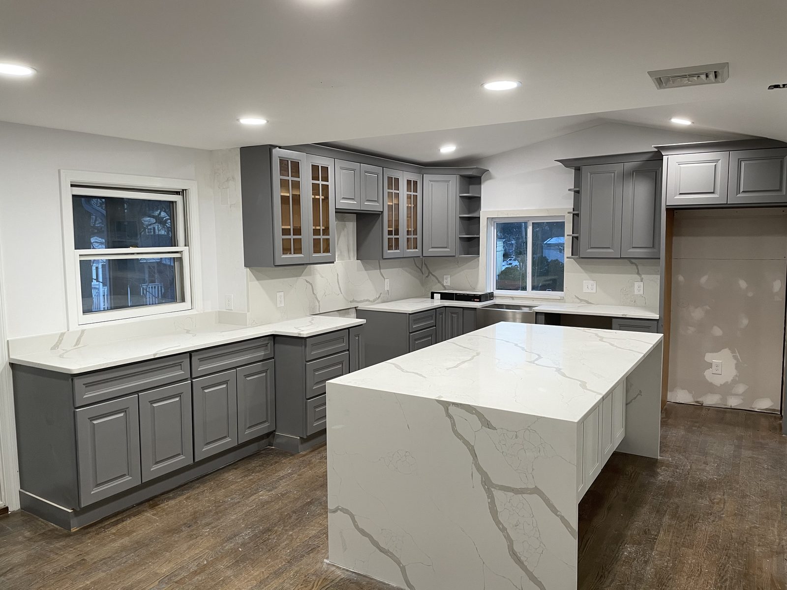 Gray kitchen with quartz waterfall island
